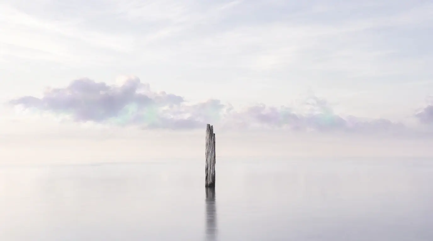 A lone sea stack beneath an iridescent pastel sky